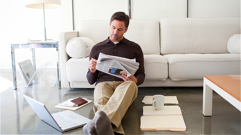 Person reviewing newspaper at home