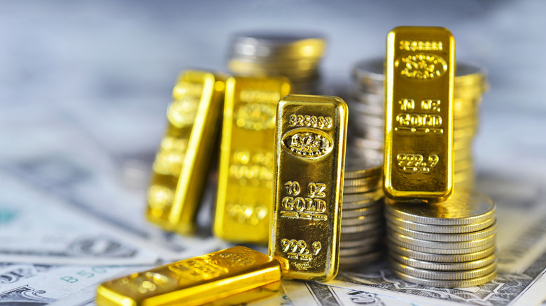Gold bars leaning against USD bills