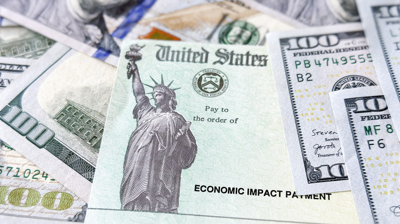 A stimulus check on a pile of money