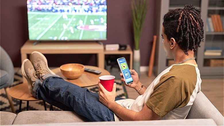 Person watching football and betting