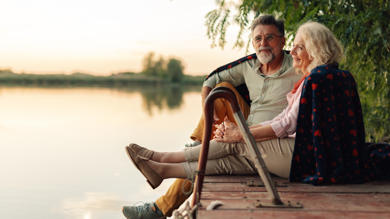 Senior couple relaxing by lake.