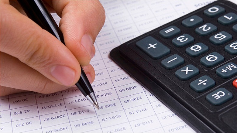 Person crunching numbers with calculator