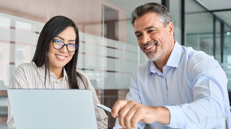 Two people smiling, on-the-job training