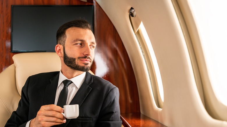 Man drinking espresso on private jet