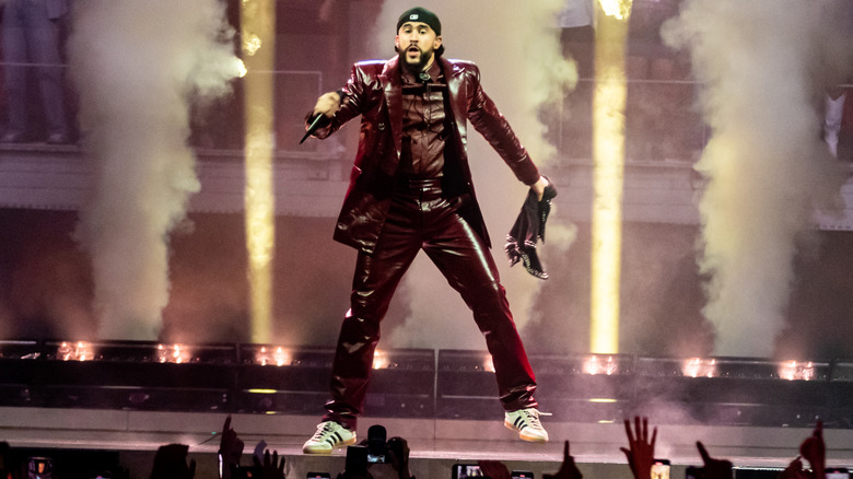 Bad Bunny performing on stage for a crowd of fans.