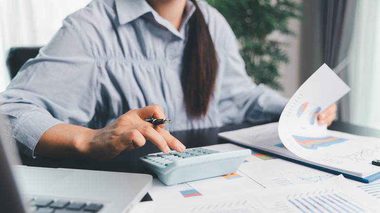 Woman using calculator to figure out her taxes