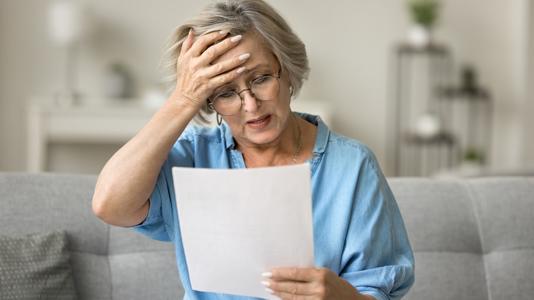Elderly woman upset looking at estimate for home repair
