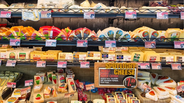 A wide view of a Trader Joe's cheese section, stocked with a wide variety of private label cheeses.