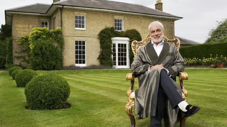 rich senior sitting on lawn in chair