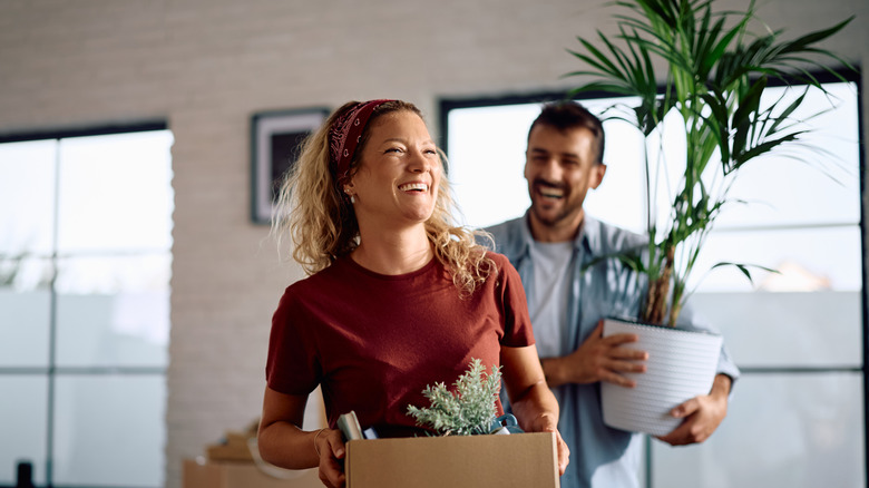 A happy couple bringing belongings into their new home.