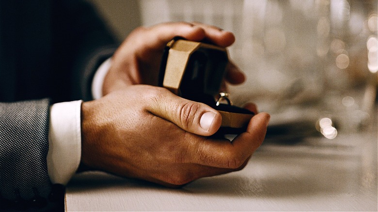 Person holding engagement ring out