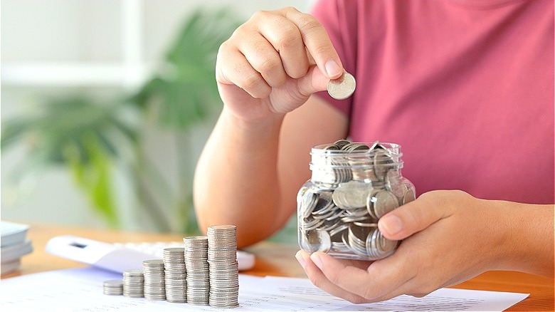 Person saving money in jar