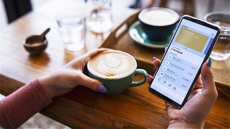 Person checking account, having coffee
