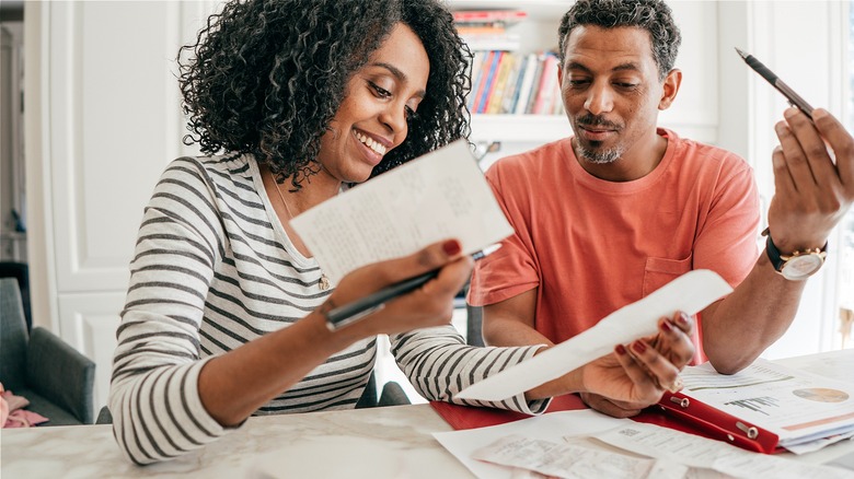 Couple smiling, looking over paperwork