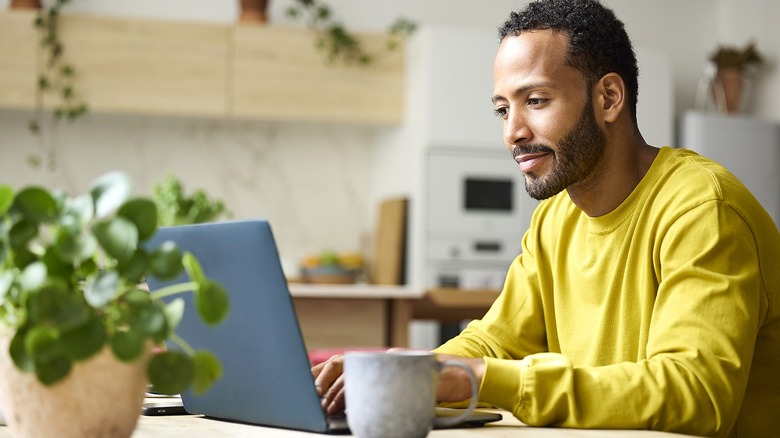 Man types from laptop while working from home