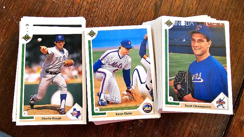 Stacks of baseball cards lying on a wooden table