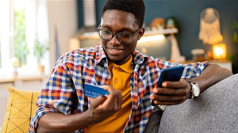 Man smiling at credit card