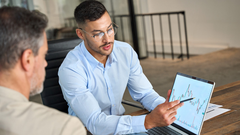 Two people analyzing a financial chart