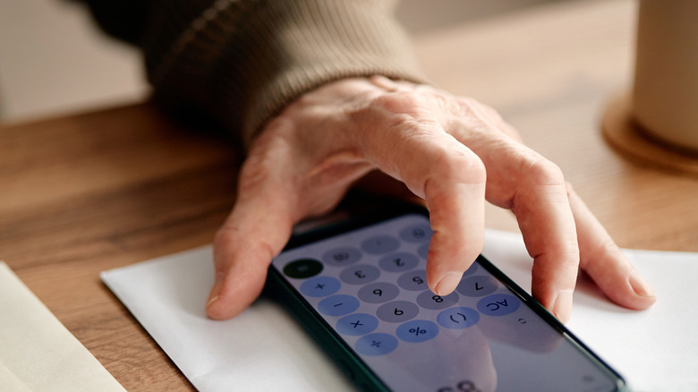 Close-up shot of a person using a calculator