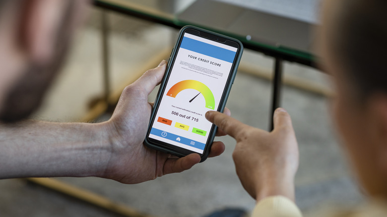 Two people looking at credit score on smartphone