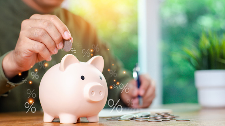 man putting money in a piggy bank