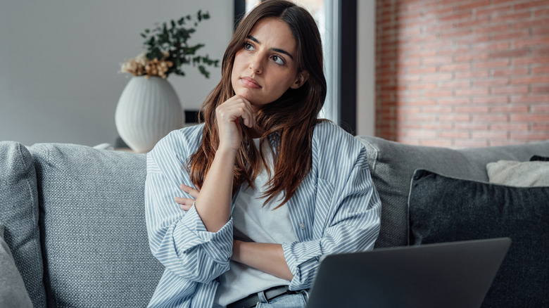 Young Gen Z woman thinking with laptop