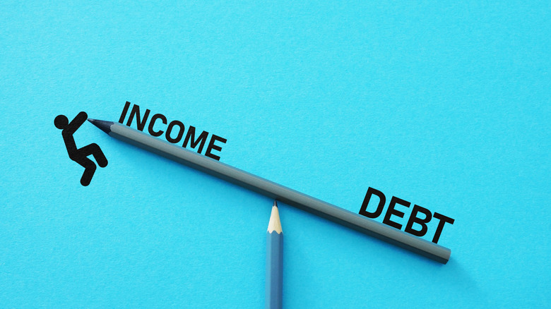 pencil see-saw with debt and income on either side