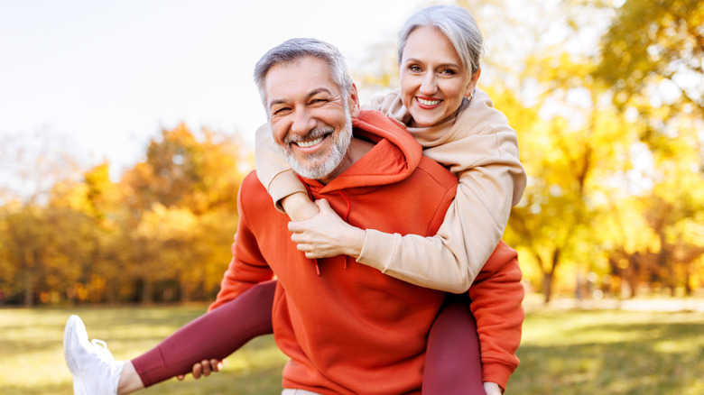 A smiling mature woman piggybacking a smiling mature woman