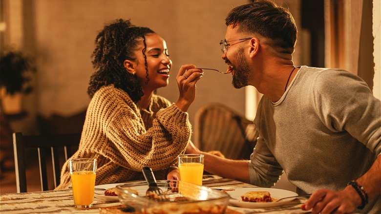 Couple feeding each other dinner