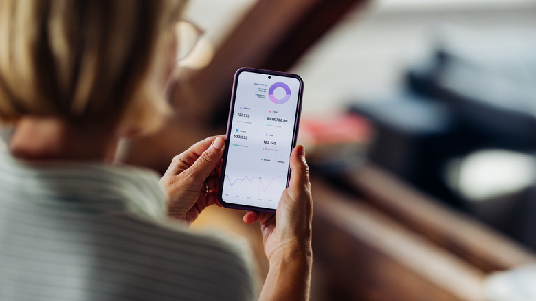 Woman looking at phone screen to track finances