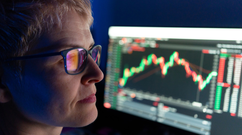 investor looking at stock data with reflection in glasses