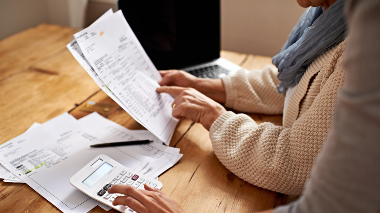 Two people looking over financial documents at a table.