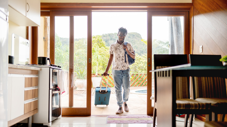 Man pulling luggage into his Airbnb rental