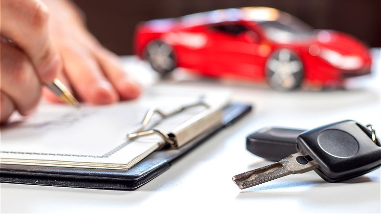 Person signing car loan document