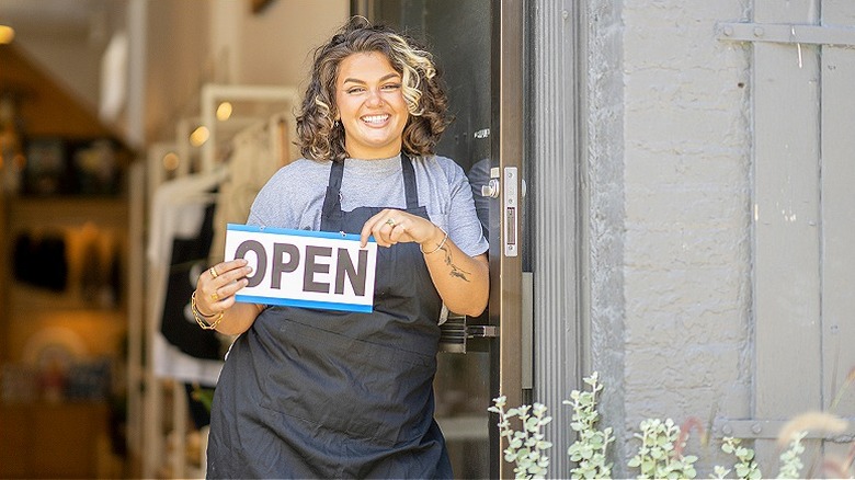Business owner with open sign
