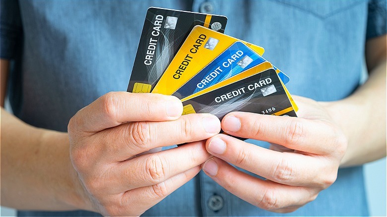 Person holding several credit cards
