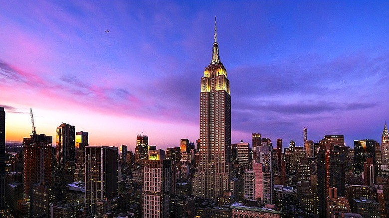 An epic shot of the Empire State Building against a purple and blue twilit sky