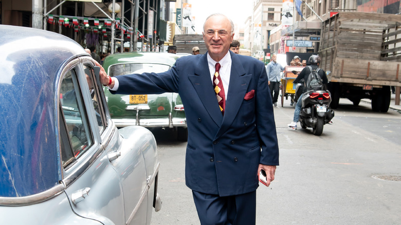 Kevin O'Leary standing on a street near a vintage car