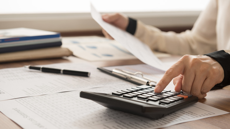 Person balancing amount info with calculator