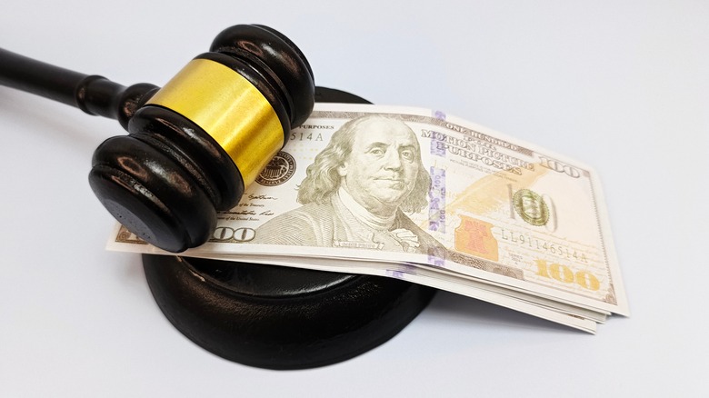 A gavel with a stack of $100 bills underneath it