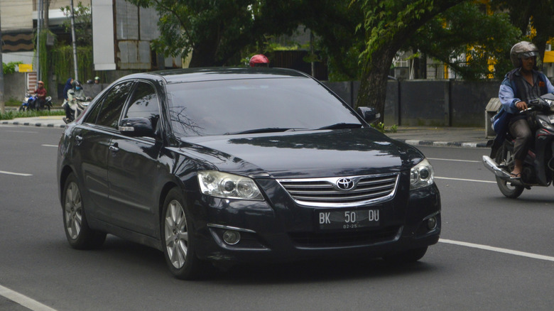 A black Toyota Camry is passing through the streets in Medan, North Sumatra, Indonesia.