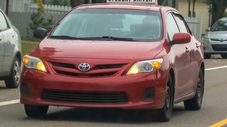A red Toyota Corolla used as a student driving vehicle.