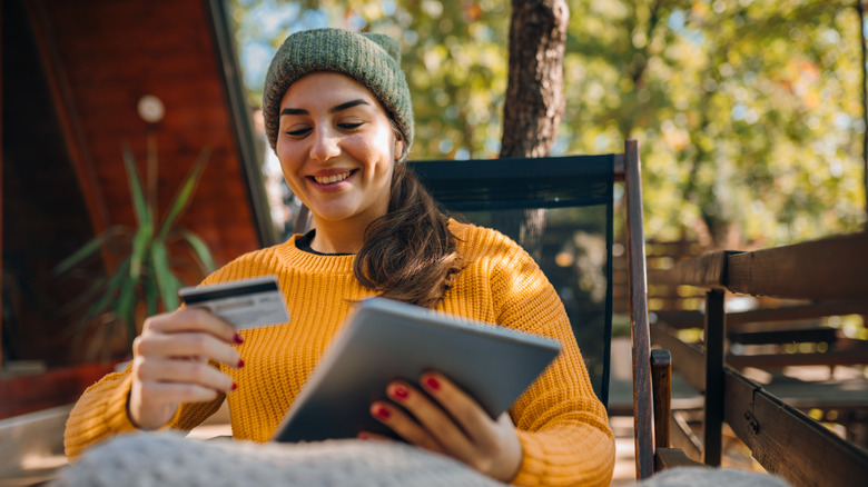 woman sitting outside holding a credit card