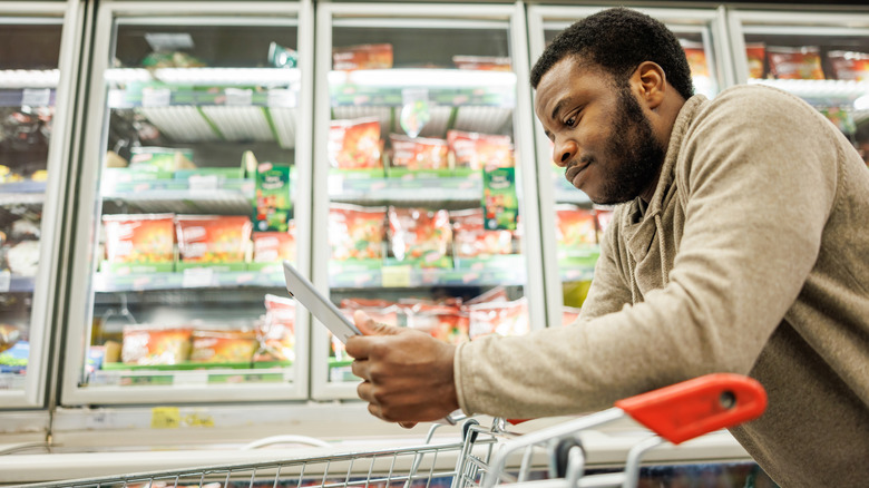 man looking at shopping list on tablet