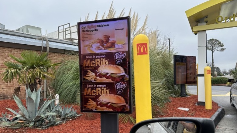 A McDonald's drive thru shows a digital screen advertising the seasonal McRib sandwich.
