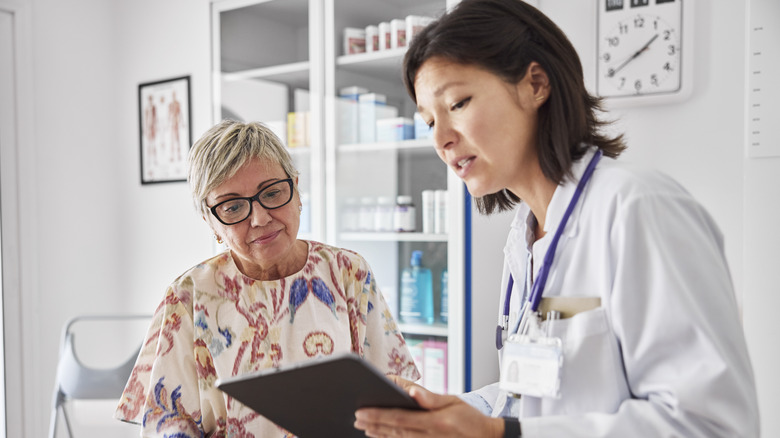 A doctor sharing electronic test results with patient at clinic.