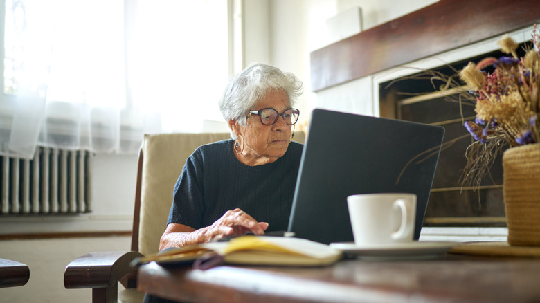 An older woman looking into her laptop