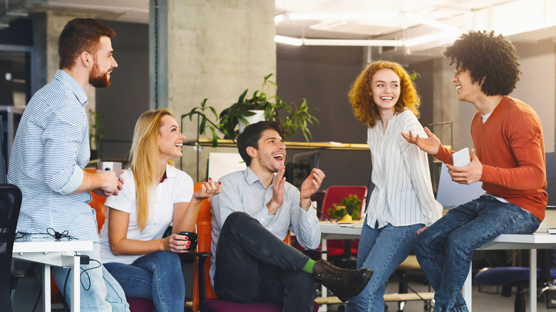 Group of millenials laughing together at work