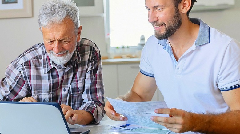 Father/son smiling, looking at computer