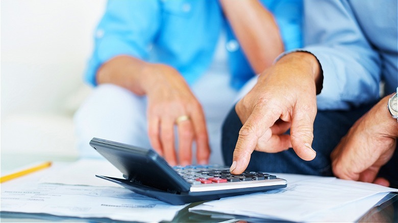 Two people calculating from paperwork